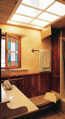 A salvaged window serves as a skylight in this bathroom.